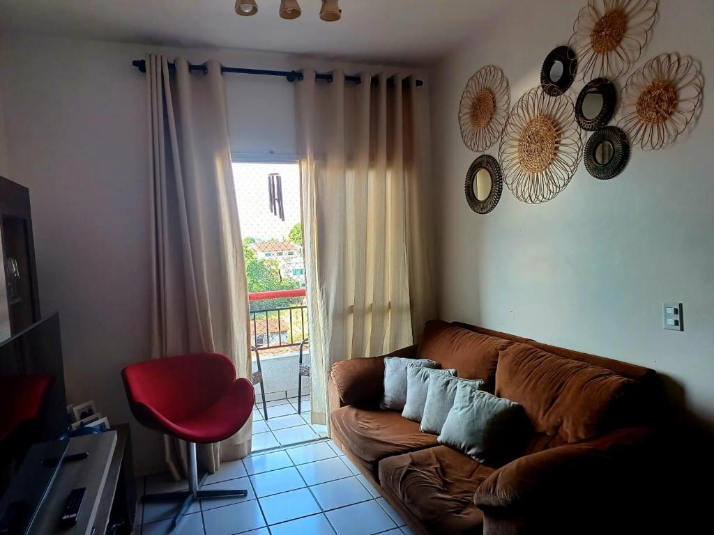 马瑙斯Apartamento Compartilhado, com 02 Quartos, sendo 01 suíte的客厅配有棕色沙发和红色椅子