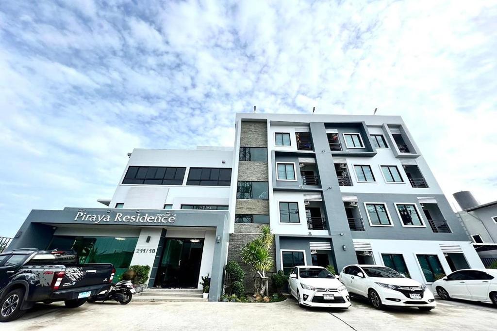 Ban Bo Sai KlangDe Piraya residence的一座白色的建筑,前面有汽车停放