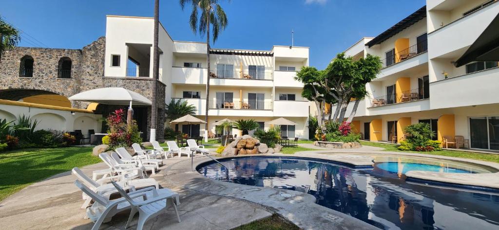 库埃纳瓦卡Casa Francisco的一座带游泳池和椅子的度假村和一座建筑