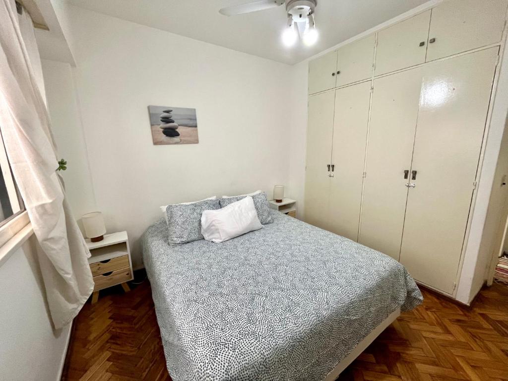 布宜诺斯艾利斯布尔内斯公寓的一间小卧室,配有一张床和白色橱柜
