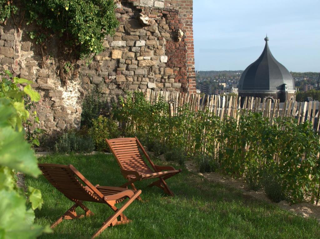 列日Bonjour Pierreuse的两把椅子坐在建筑物旁边的草上