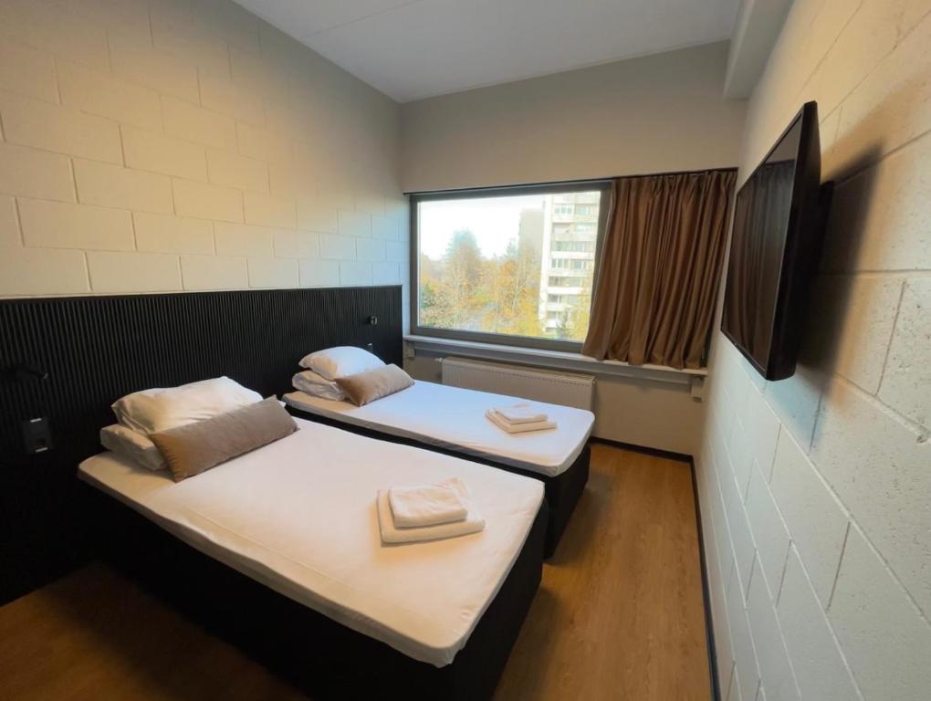 塔林RING Sport Hostel的带窗户的客房内的两张床
