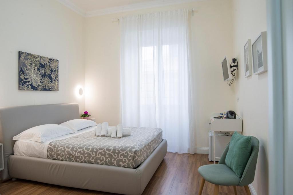 罗马Francy Guest House的白色卧室配有床和蓝椅