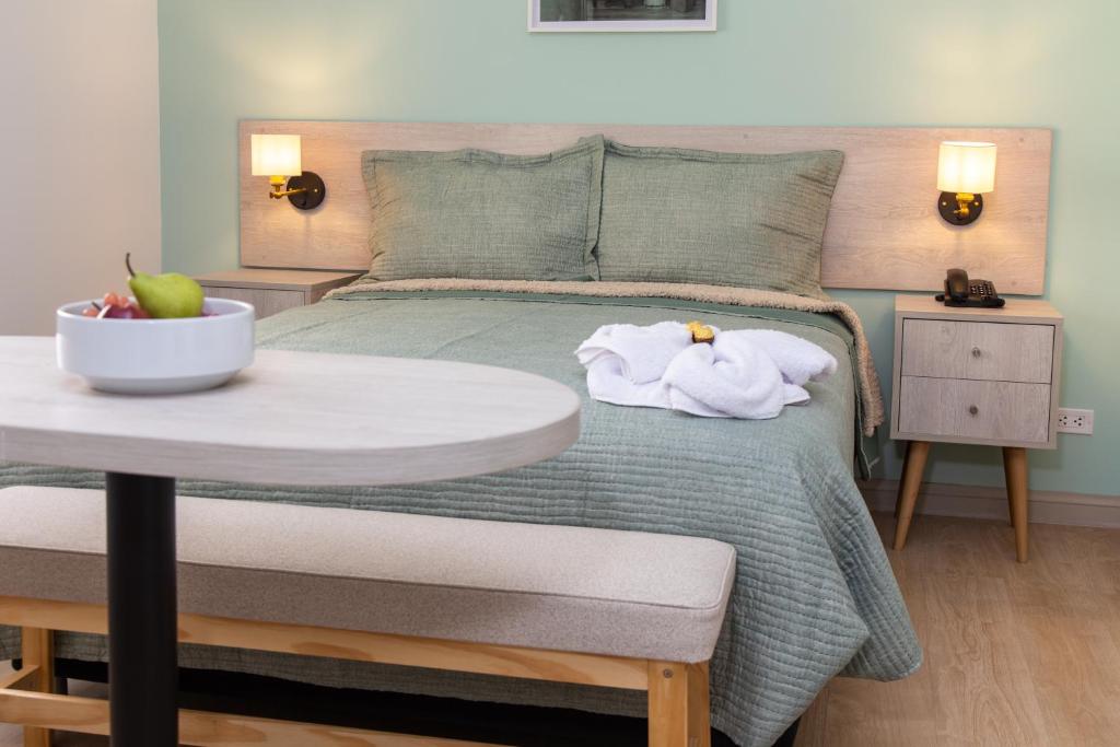 利马Hotel San Blas的一间卧室配有一张带桌子和毛巾的床