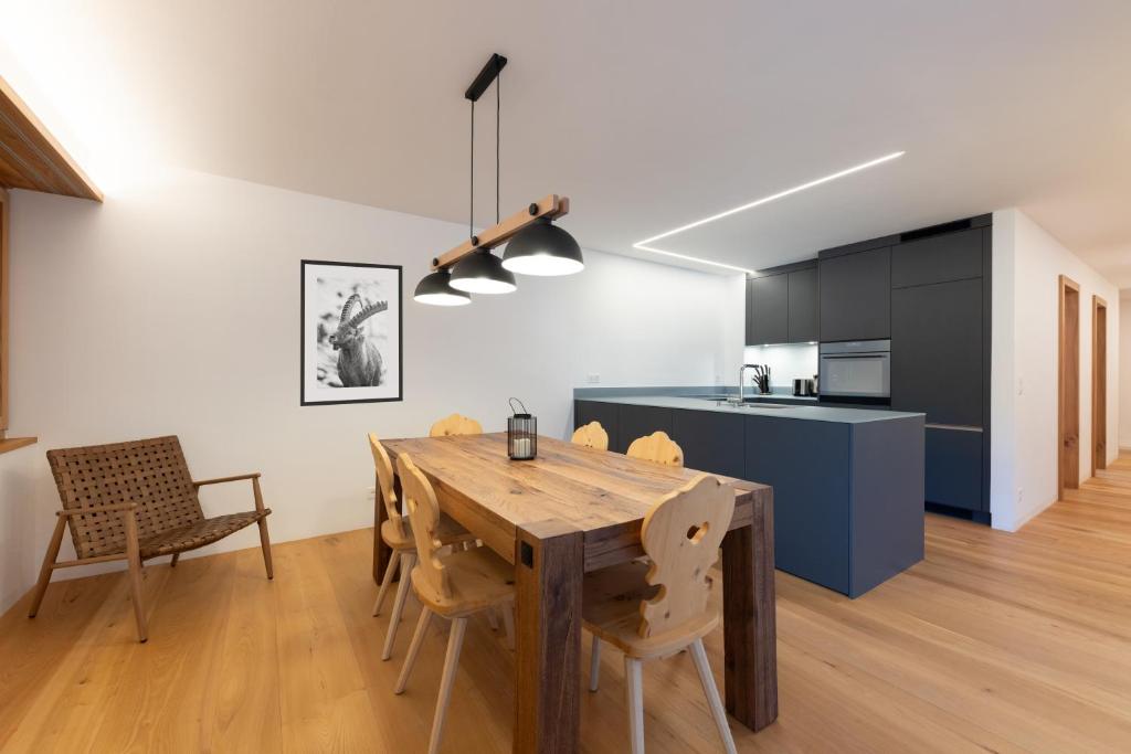 圣莫里茨New! Exclusive Apartment 3min to Chantarella Bahn的厨房以及带木桌和椅子的用餐室。