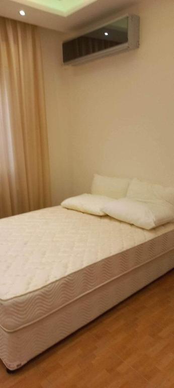 安曼عمان الاردن الدوار الخامس的一张铺有白色床单的床和一个窗户