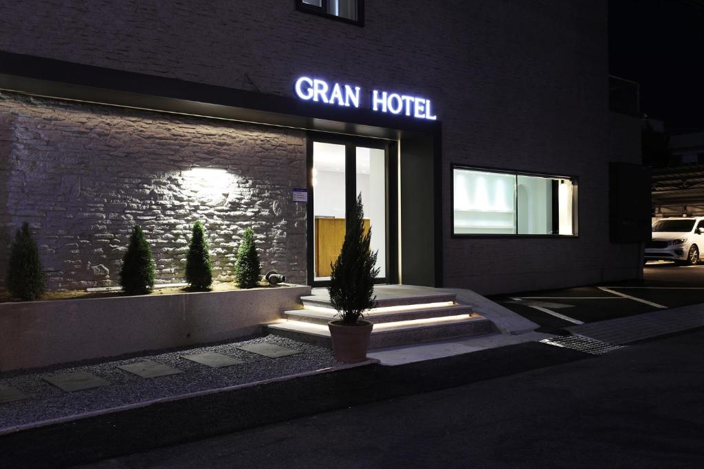 群山市Gran Hotel的一座带有绿色酒店标志的建筑