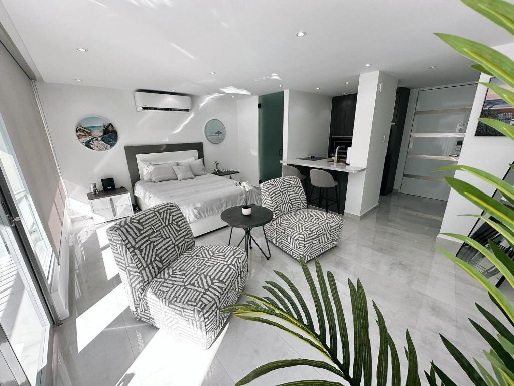 圣胡安Ocean Front Coral Luxury Apartment的一间卧室配有一张床、两把椅子和一张桌子