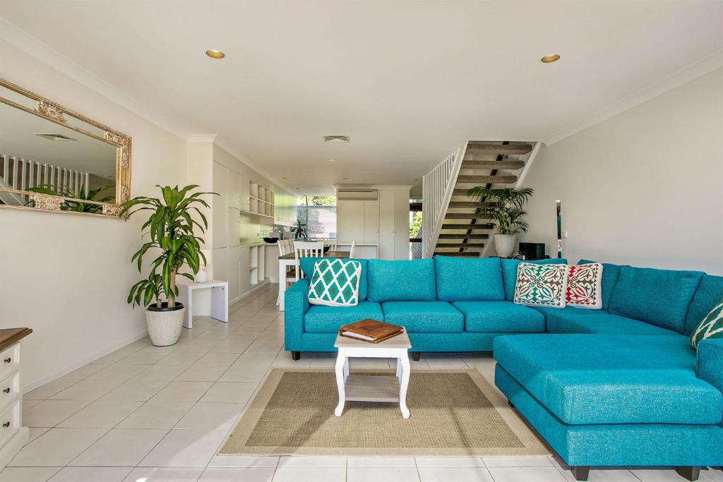 拜伦湾A Perfect Stay - 2 James Cook Apartments的客厅配有一张蓝色的沙发,配有一张桌子