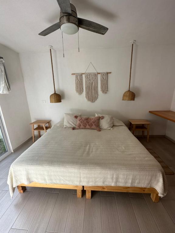 NautlaBoca de agua Villas的一间卧室配有一张大床和吊扇