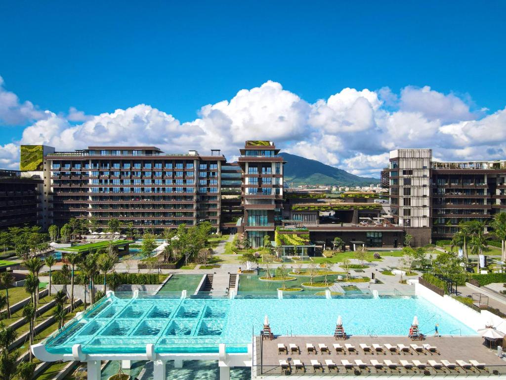 三亚 三亚1Hotel海棠湾阳光壹酒店（可持续发展理念）的一座带大型游泳池和建筑的度假村