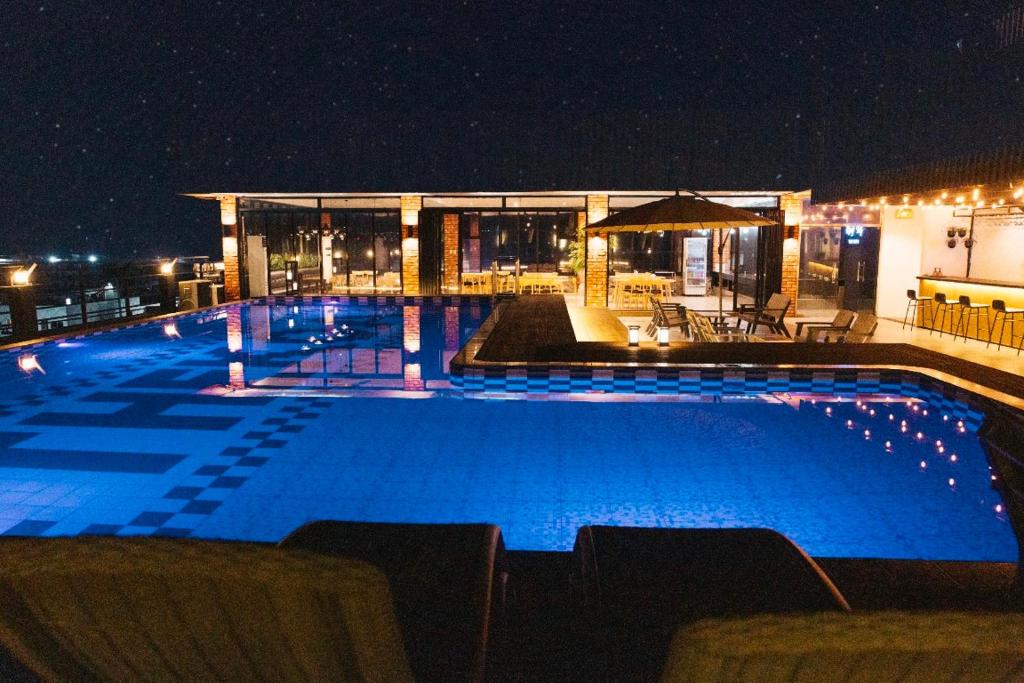 安吉利斯THE KOA Hotel & Spa的一座游泳池,晚上与大楼相连