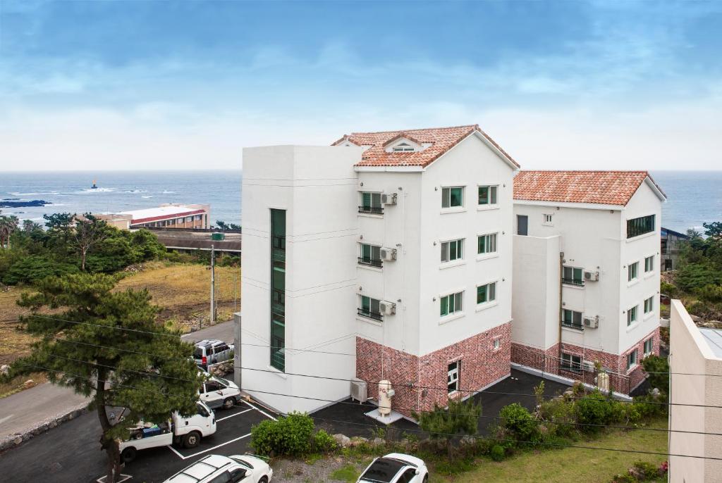济州市Jeju Aria Pension的公寓大楼的背景是大海