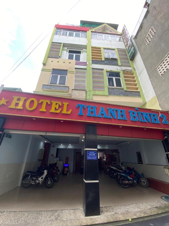 胡志明市Thanh Bình 2 Hotel的一座酒店大厦,前面停有摩托车