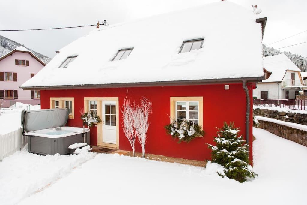 瑟温Doller Villa 4 stars Hot Tub Mountain Ski Ballon d'Alsace的一座红色的房子,地面上积雪