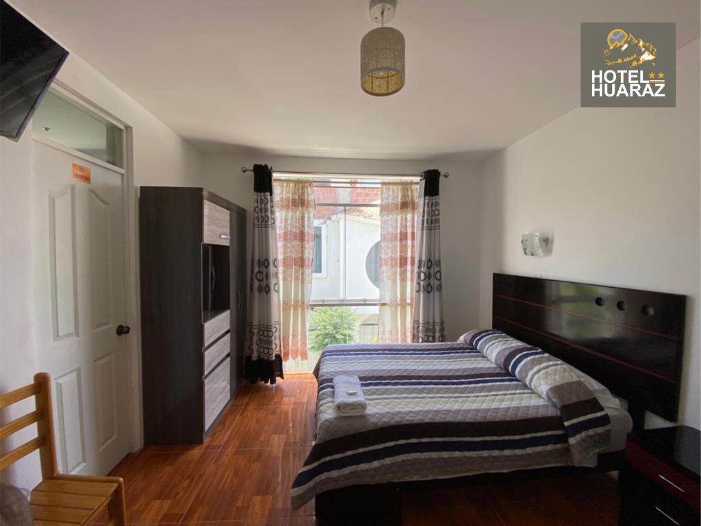 塔克纳HOTEL HUARAZ的一间卧室设有一张床和一个大窗户