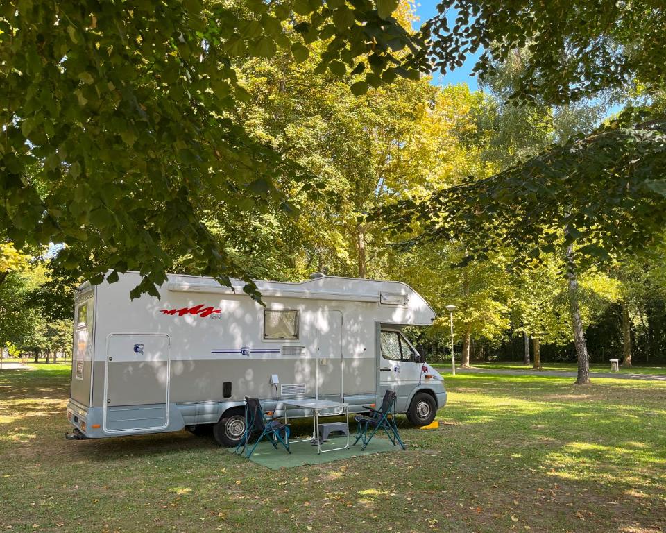 佐洛卡罗斯Thermal Camping Zalakaros的停在树下公园里的白色大篷车
