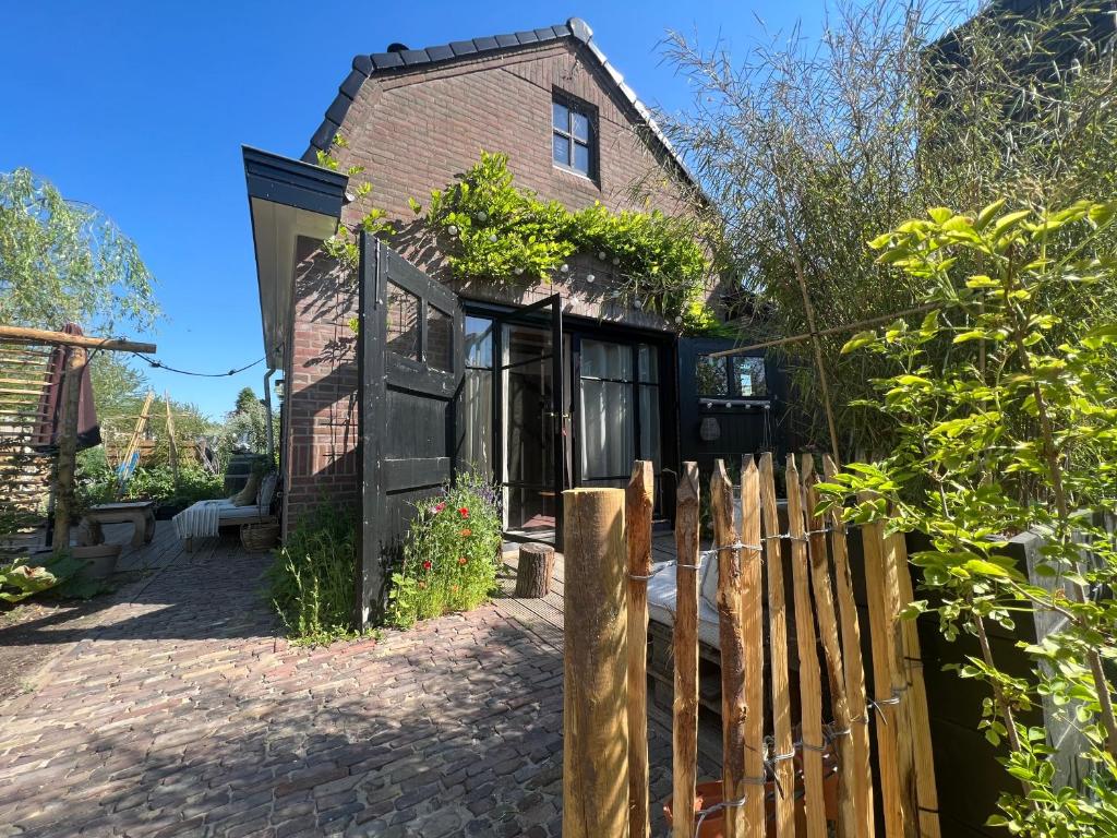 鹿特丹Guesthouse Rotterdam, tinyhouse nearby Kralingen的前面有木栅栏的房子
