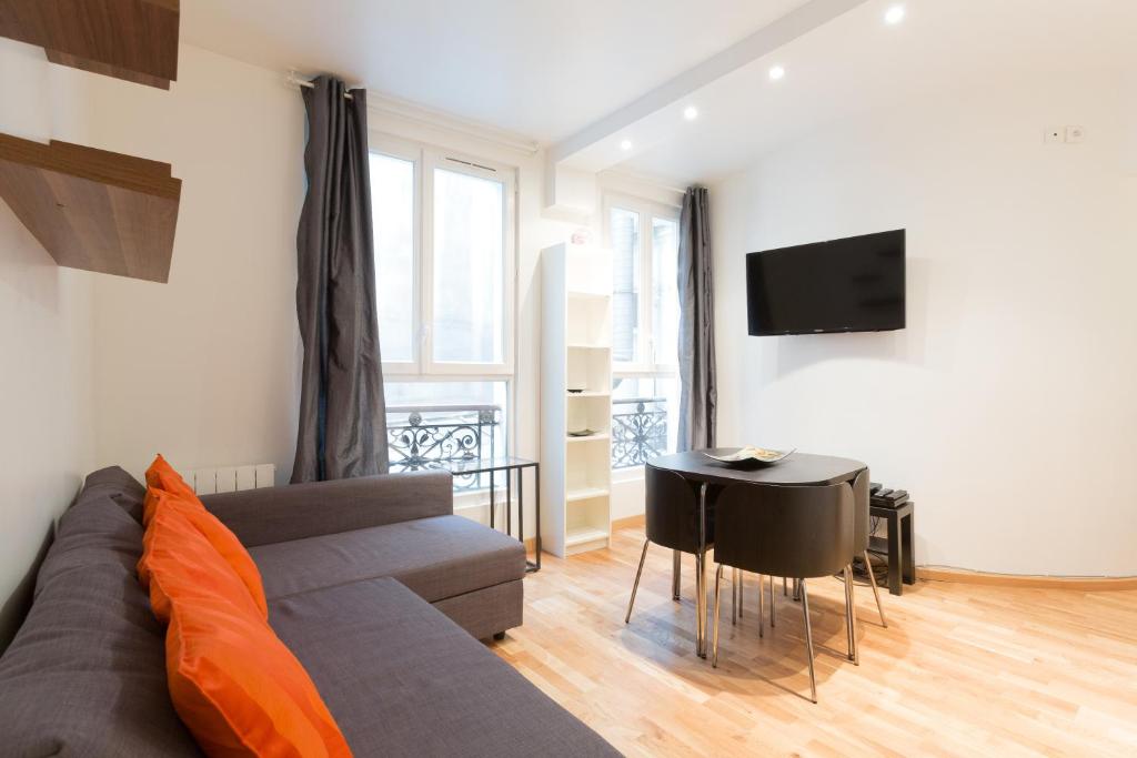 巴黎佩提香榭丽舍公寓的客厅配有沙发和桌子
