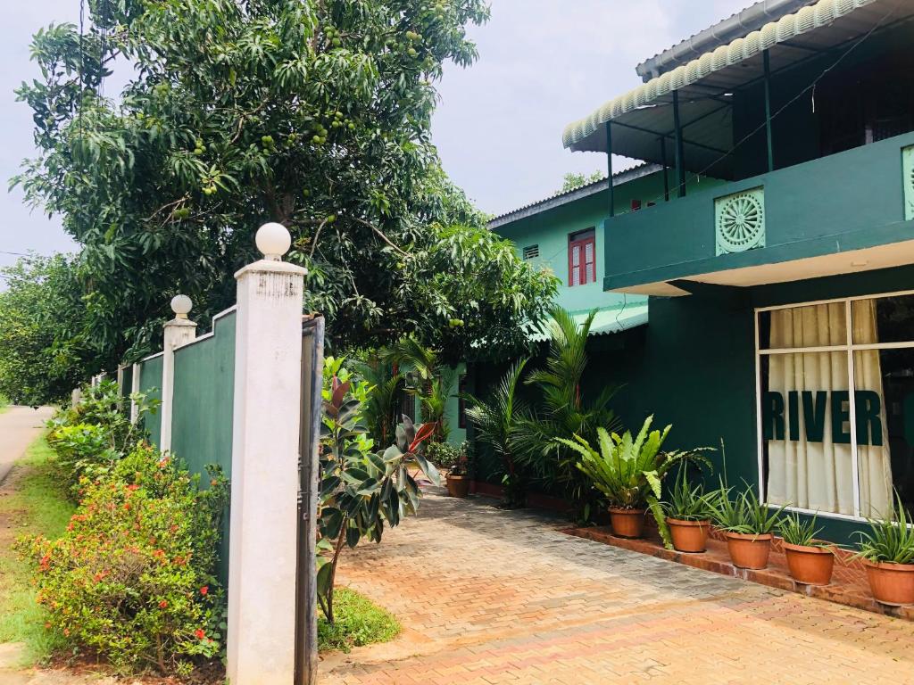 阿努拉德普勒River Garden Hotel Anuradhapura的绿色建筑前的围栏