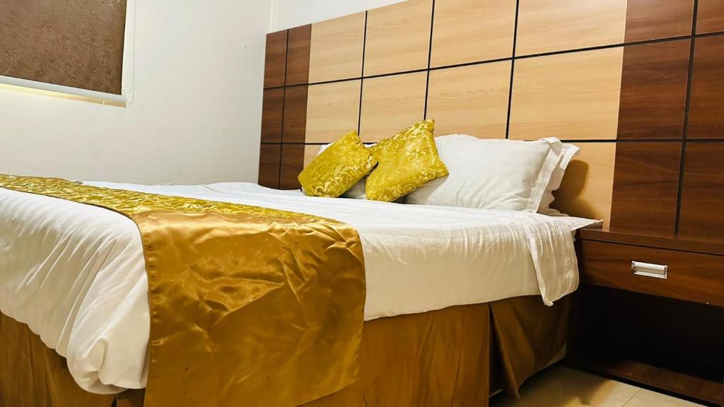 麦地那Basma Suites的床上有两张黄色枕头