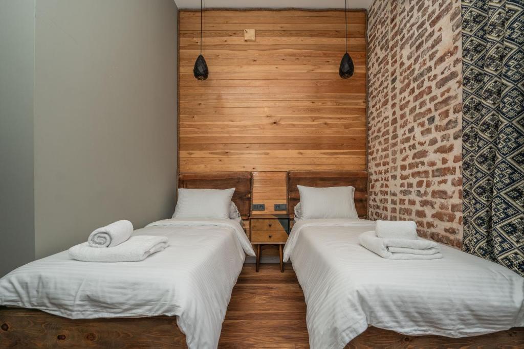 克瓦雷利Hotel Piano Kvareli的木墙客房 - 带两张单人床