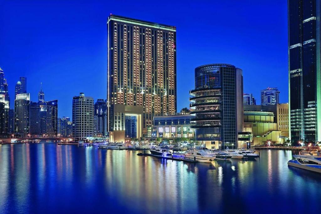 迪拜Address Marina Mall Suites "Full Marina Views & Balcony "的城市天际线,夜间在水中划船
