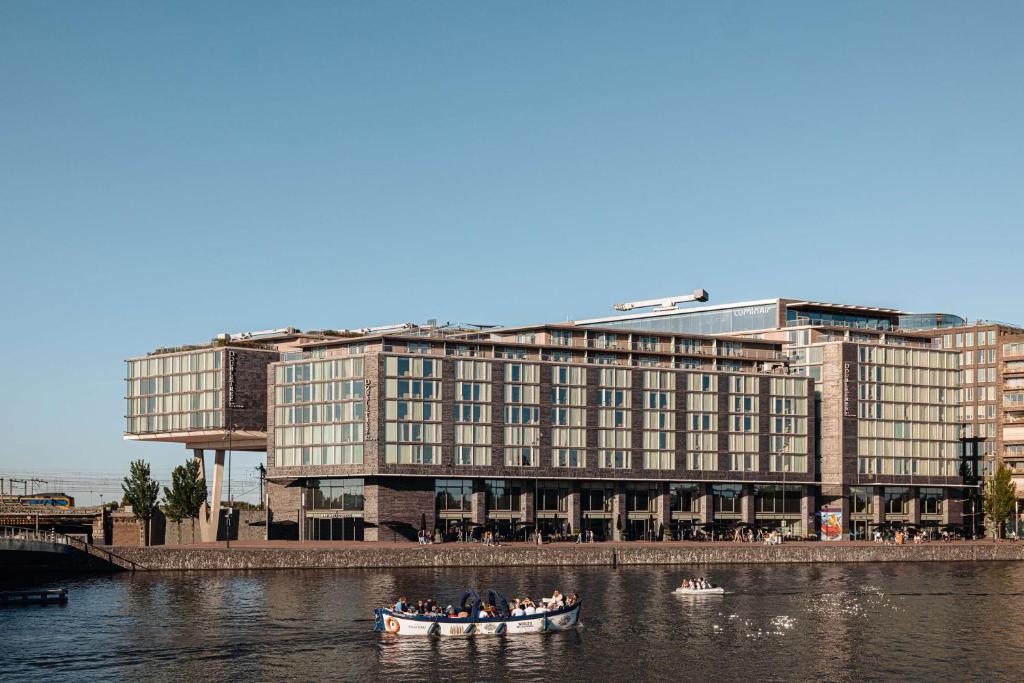阿姆斯特丹阿姆斯特丹中央车站希尔顿逸林酒店的一群人,在河里,在有建筑物的船上