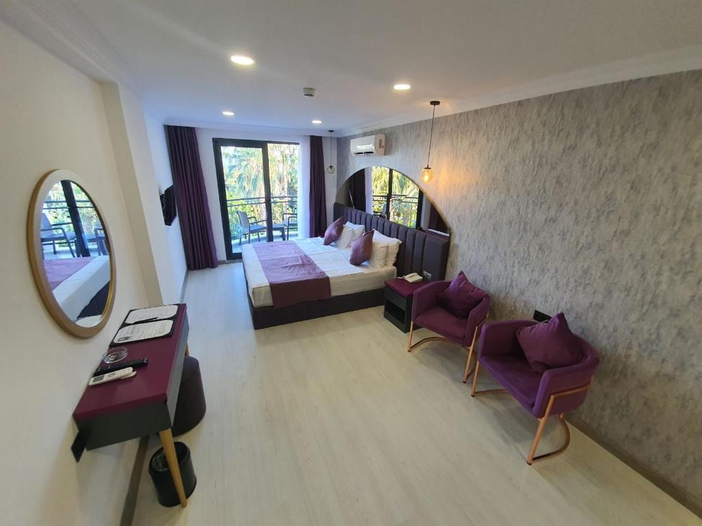 阿拉尼亚Karikatür Bi Hotel的卧室配有一张床和一张桌子及椅子