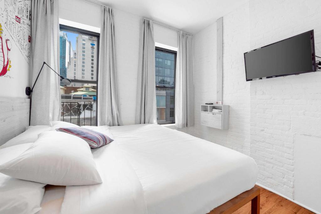纽约BeHome by LuxUrban的白色的卧室设有白色大床和窗户