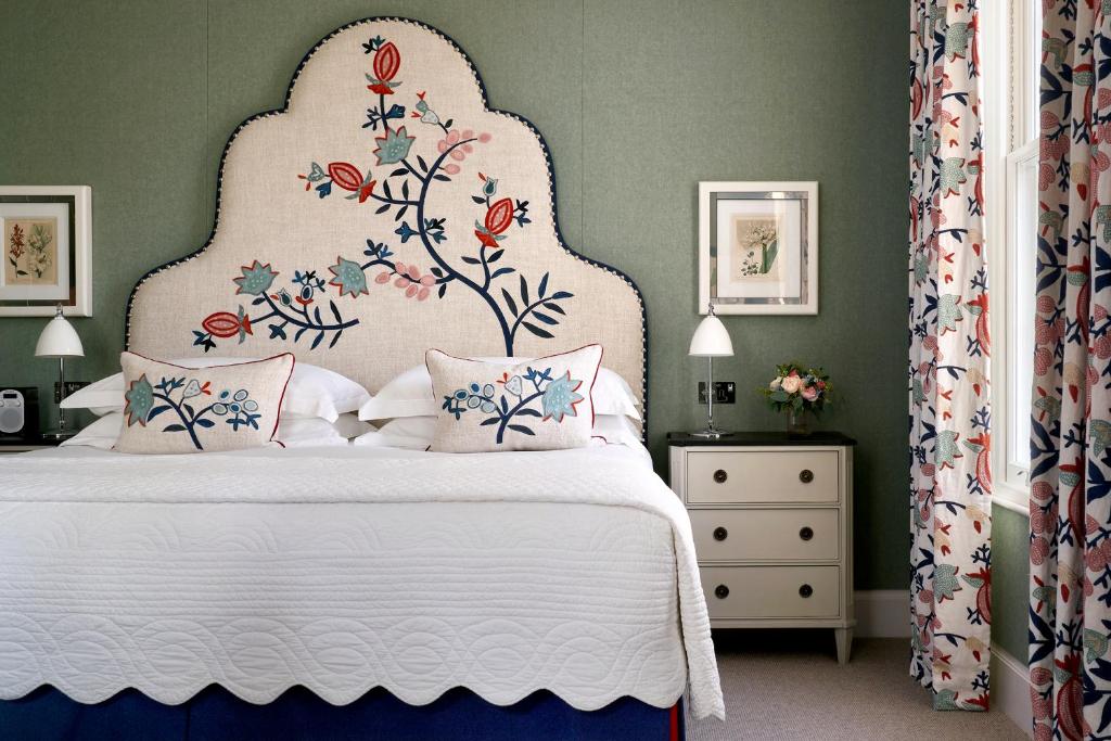 伦敦菲尔姆戴尔酒店集团禧市酒店的卧室配有白色床和花卉床头板