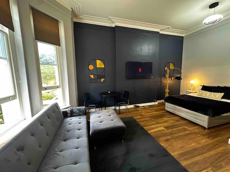 伦敦Stylish studio for 3 near Regent’s Park n3的客厅配有沙发和一张床