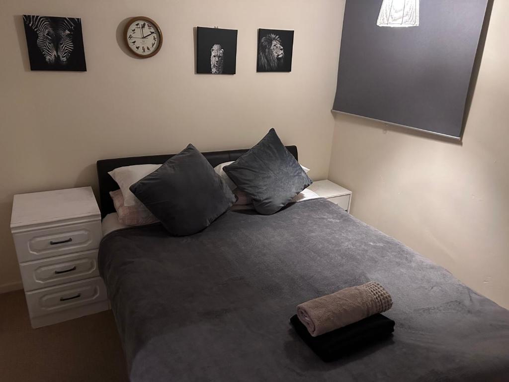 巴塞尔顿Genesis place的卧室配有一张床,墙上挂着一个钟