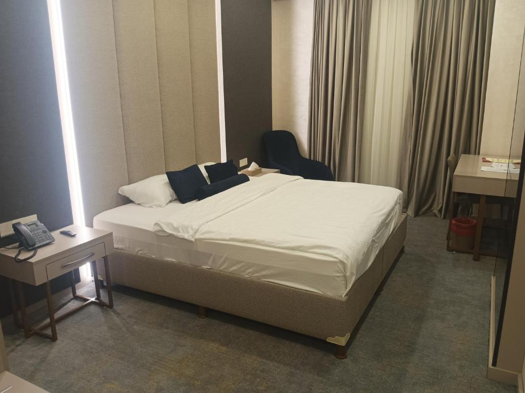 埃尔比勒达林广场酒店 的一间卧室配有一张床、一把椅子和一张书桌