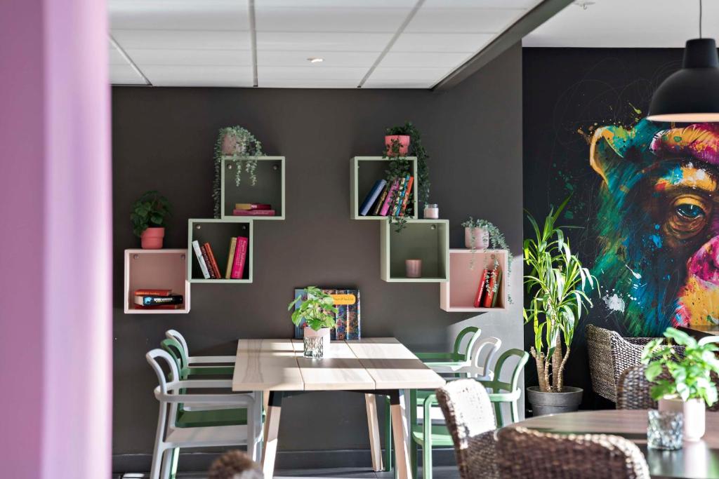 索尔纳Aiden by Best Western Stockholm Solna的一间设有桌子和墙上绘画的用餐室