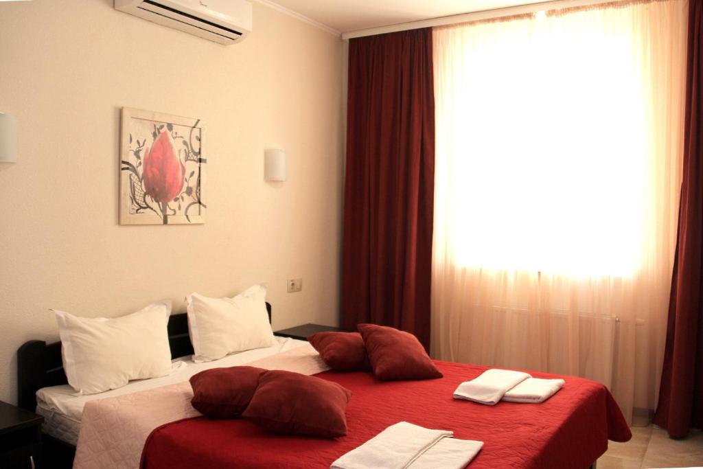 敖德萨布瑞姿酒店的一间卧室设有两张带红色床单的床和窗户。