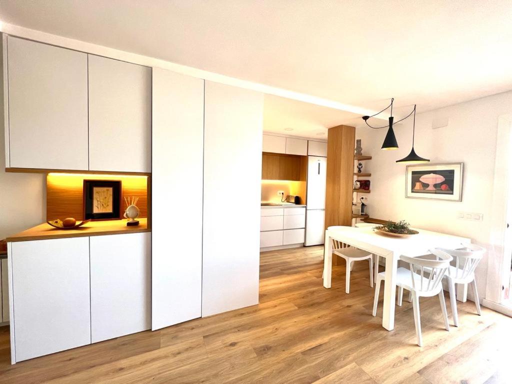比利亚努埃瓦-赫尔特鲁Ancora Apartment的厨房以及带白色橱柜和桌子的用餐室。