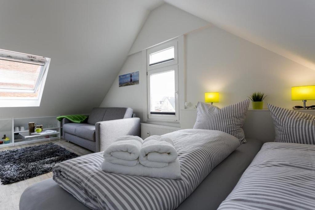 博尔库姆Haus Nordstern Wohnung 5的客厅配有沙发和两个枕头