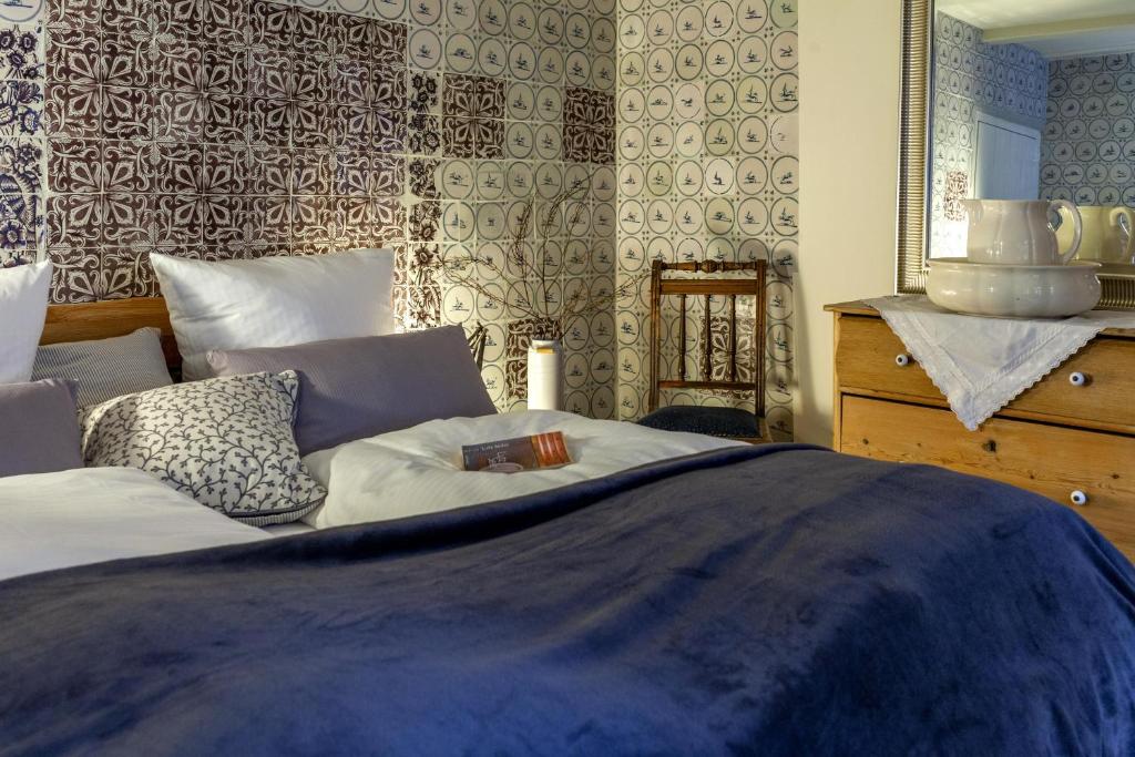博尔库姆Commandeur-Huus Wohnung 2的一间卧室配有一张带蓝色棉被的床