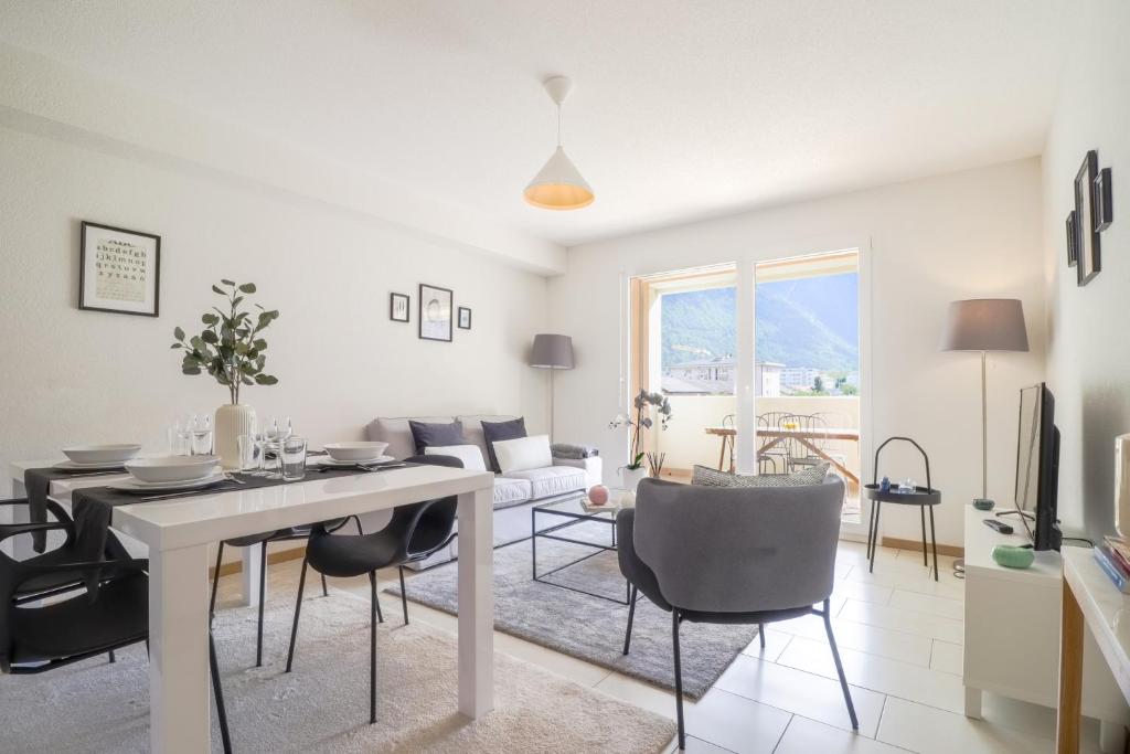 马蒂尼威尔Modern apartment close to Martigny train station的白色的客厅配有桌椅