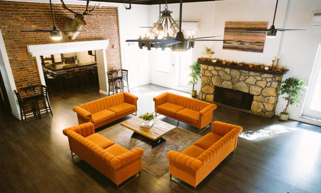 圣克卢亨特阿姆斯酒店的客厅配有橙色家具和壁炉