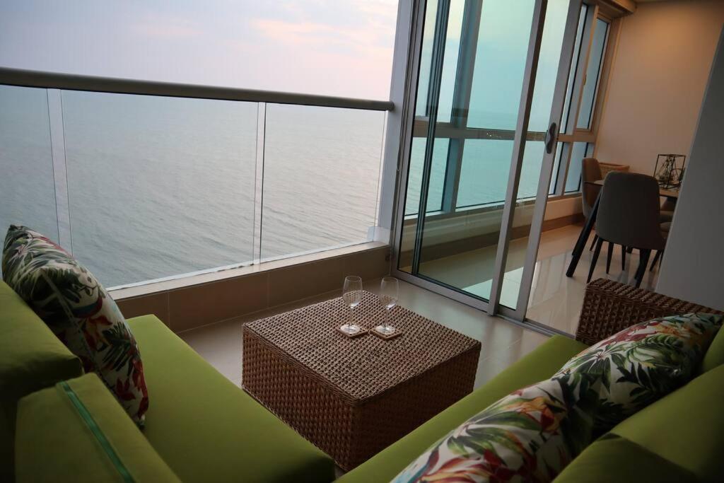 卡塔赫纳Palmetto Sunset 2903 with an amazing ocean view的客厅配有绿色沙发和桌子