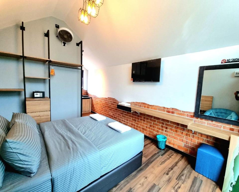 金马仑高原Campod Resort @ Cameron Highlands的一间卧室设有一张床和砖墙