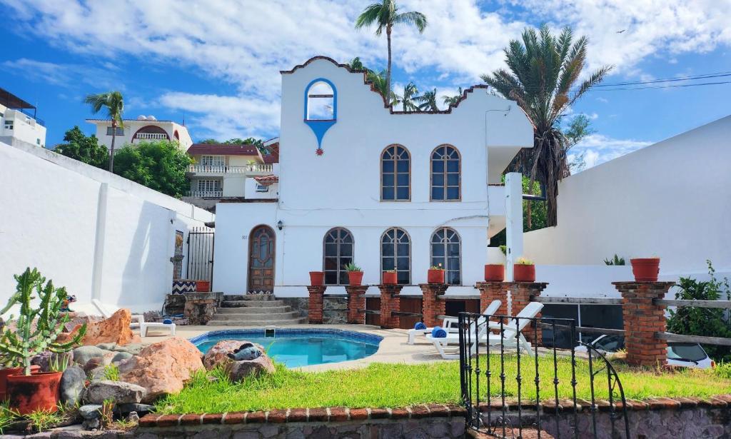 马萨特兰Hill House Mazatlan - Bed & Breakfast的一座白色的房子,前面设有一个游泳池