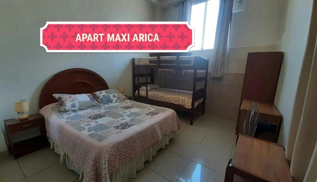 阿里卡Apart Maxi的一间卧室配有一张床和一个标志,可读取主区