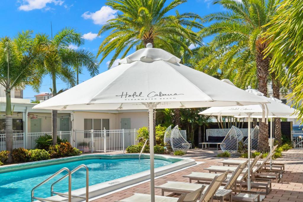 克利尔沃特Hotel Cabana Clearwater Beach的游泳池旁的游泳池配有椅子和遮阳伞