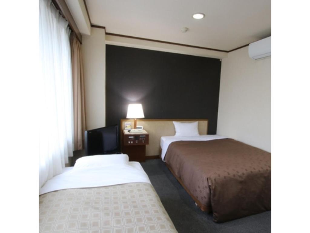 堺市Hotel Aston Hotel Osaka Sakai - Vacation STAY 97562v的酒店客房设有两张床和黑色墙壁。