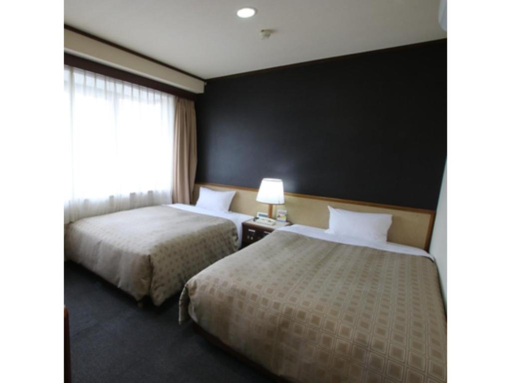 堺市Hotel Aston Hotel Osaka Sakai - Vacation STAY 97585v的一张位于酒店客房的床铺,设有黑色的墙壁