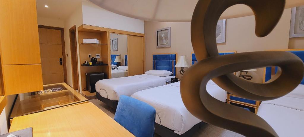 纳杰夫Al Sahla Land Hotel的酒店客房,设有两张床和象征性的雕像