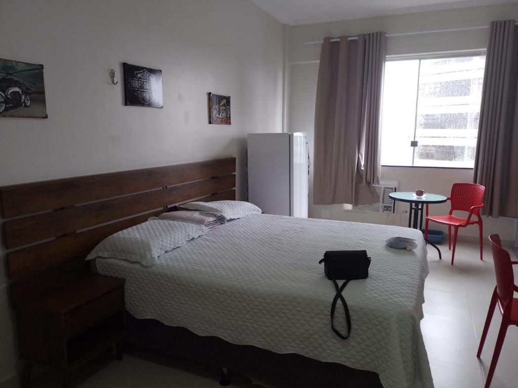 马瑙斯Temporada centro de Manaus 815的一间卧室配有一张床和一张桌子及椅子